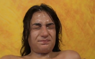 Cute brunette on her knees enjoys getting face jizz covered